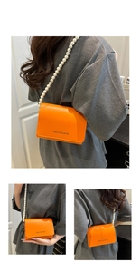 Détail du sac bandoulière orange avec bandoulière en perles et lettrage noir