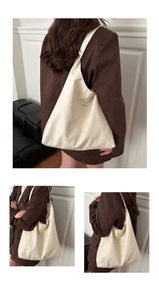 Detail view of cream white oversized hobo bag showing pebbled texture and gold fashion logo