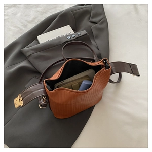 Detail showing the pleated brown PU leather bucket bag with spacious interior and gold hardware