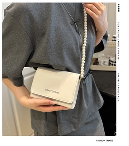 Détail du sac bandoulière élégant en similicuir crème avec bandoulière en perles