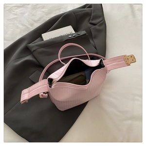 Close-up of pink textured handbag showing interior storage space and gold buckle
