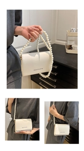 Gros plan sur le sac blanc avec bandoulière en perles et détail du rabat de marque
