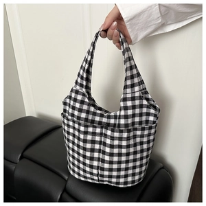 Detail shot of checkered canvas bucket bag featuring two functional front pockets