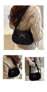 Détail du sac sous l'aisselle plissé noir avec broderie de nœud blanc et tissu en velours
