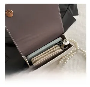 Vue intérieure du sac en similicuir blanc avec perles montrant l'espace de rangement