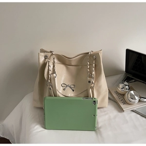 Détail du sac cabas crème avec nœud argenté montrant sa grande capacité pour tablette