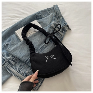 Détail du sac à bandoulière en velours côtelé noir avec broderie nœud et bandoulière