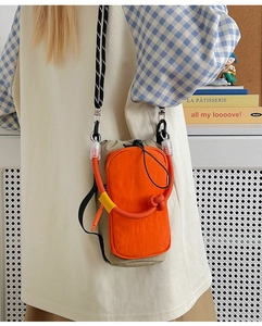 Vue détaillée du sac bandoulière orange et kaki en nylon résistant à l'eau