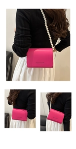 Détail du sac à bandoulière en cuir rose avec sangle en perles et lettrage imprimé