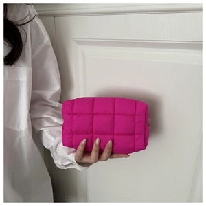 Close-up of quilted rose pink nylon makeup bag with premium gold metal zipper detail