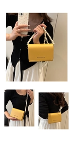 Détails du sac à bandoulière jaune avec poignée en perles et logo sur la face avant