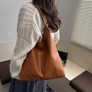 Vintage large brown PU leather tote bag with gold lettering shown on a model