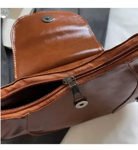 Detail view of brown vintage saddle bag featuring smooth zipper and oil wax leather texture