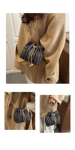 Detail of woven bucket bag featuring herringbone pattern and elegant pearl drawstring accents