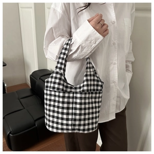 Close-up of black and white gingham canvas bucket bag with dual front pockets for women