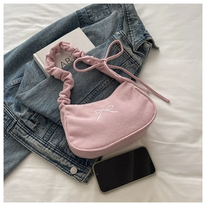 Vue détaillée du sac à bandoulière en velours côtelé rose avec broderie nœud blanc