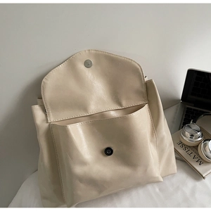 Détail du sac cabas brillant crème avec fermeture magnétique et grande poche frontale