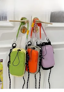 Trois sacs bandoulière colorés en nylon avec cordon de serrage et bandoulière tressée