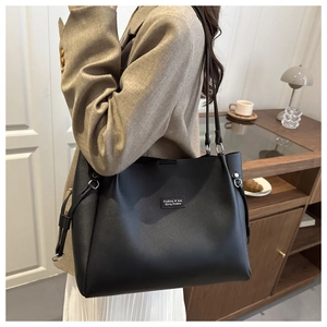 Borsa tote nera classica di grande capacità indossata a spalla per donna chic