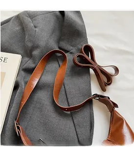 Detailed view of adjustable brown leather shoulder straps with metallic buckles