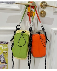 Détail de mini sacs bandoulière en nylon avec cordon de serrage et bandoulières colorées