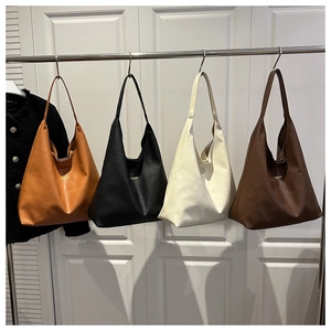 Macro view of textured soft leather tote bags in orange, black, white, and brown colors