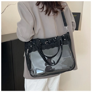 Détail du sac transparent noir avec boucle en métal en forme de cœur et bandoulière