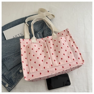 Detailed view of pink corduroy heart tote bag with dual handles and front pockets
