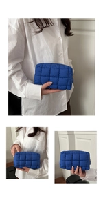 Close-up of a navy blue quilted cosmetic bag with soft texture and golden zipper