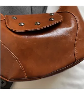 Close-up of brown vintage saddle bag with metallic cone studs and retro leather texture