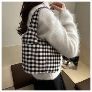 Close-up of checkerboard canvas tote bag showing black and white texture and stitching