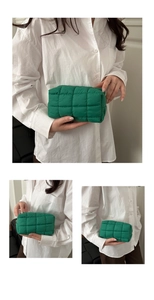 Macro detail of vibrant green quilted pouch showing soft padded square texture