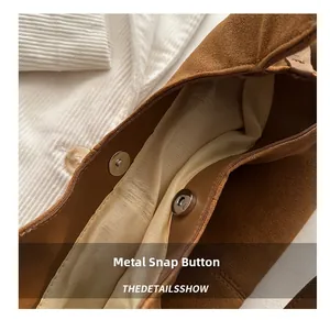 Detail shot of the magnetic snap closure on a vintage brown suede tote bag