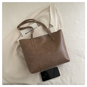 Detail view of the retro brown tote bag with fashion bags logo on a blazer background