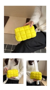 Close-up of vibrant yellow quilted puffer cosmetic bag with classic square stitching