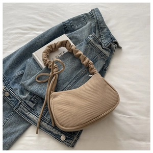 Détail du sac à bandoulière en velours côtelé kaki avec anse plissée et nœud décoratif