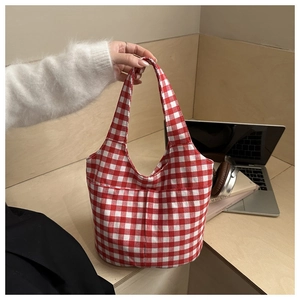 Detailed view of red and white gingham tote bag in a casual lifestyle setting