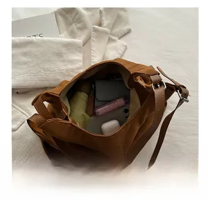 Interior view showing large capacity of the brown suede tote bag with daily essentials