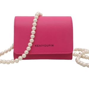 Sac bandoulière chic en cuir rose avec bandoulière en perles blanches et rabat