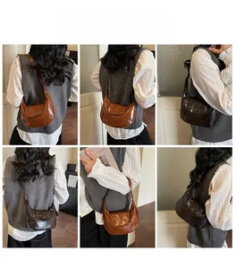 Detail of studded crescent hobo bag with wrinkled texture in brown and dark coffee