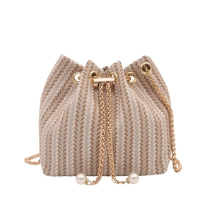 Minimalist beige woven bucket bag with gold chain strap and pearl accents