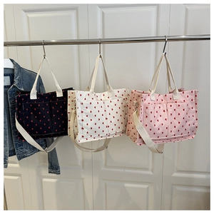 Detailed view of corduroy tote bags with heart patterns in blue, beige and pink