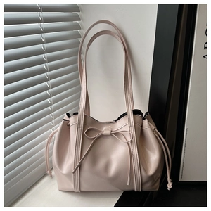 Close-up of pink ribbon tote bag with drawstring detail and glossy leather texture