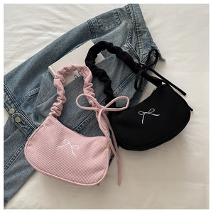 Détail de sacs en velours côtelé rose et noir avec broderie nœud et poignées plissées stylées