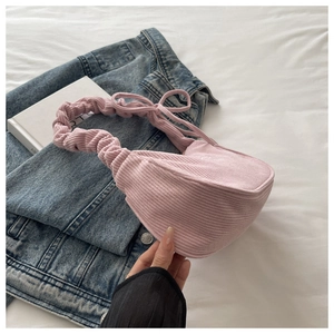 Détail du sac à bandoulière en velours côtelé rose avec nœud et bandoulière froncée