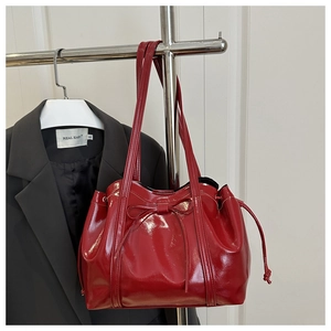 Chic red patent leather dumpling bag with bow detail and adjustable side drawstrings