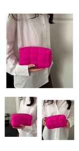 Detailed macro view of vibrant rose red quilted makeup bag with square stitching patterns