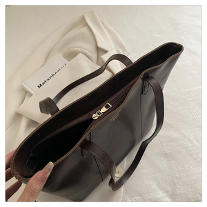 Close-up of the large capacity coffee brown tote bag with metal zipper and fine leather texture