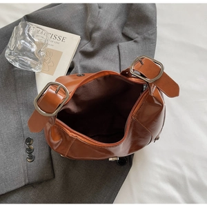 Top view of caramel faux leather bag interior showing zipper and adjustable silver buckle