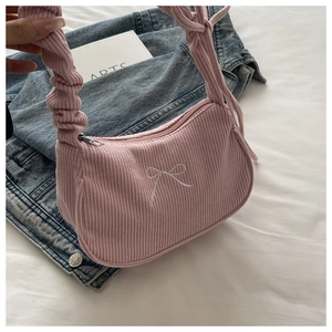 Détail du sac bandoulière en velours côtelé rose avec nœud brodé et bandoulière à froufrous